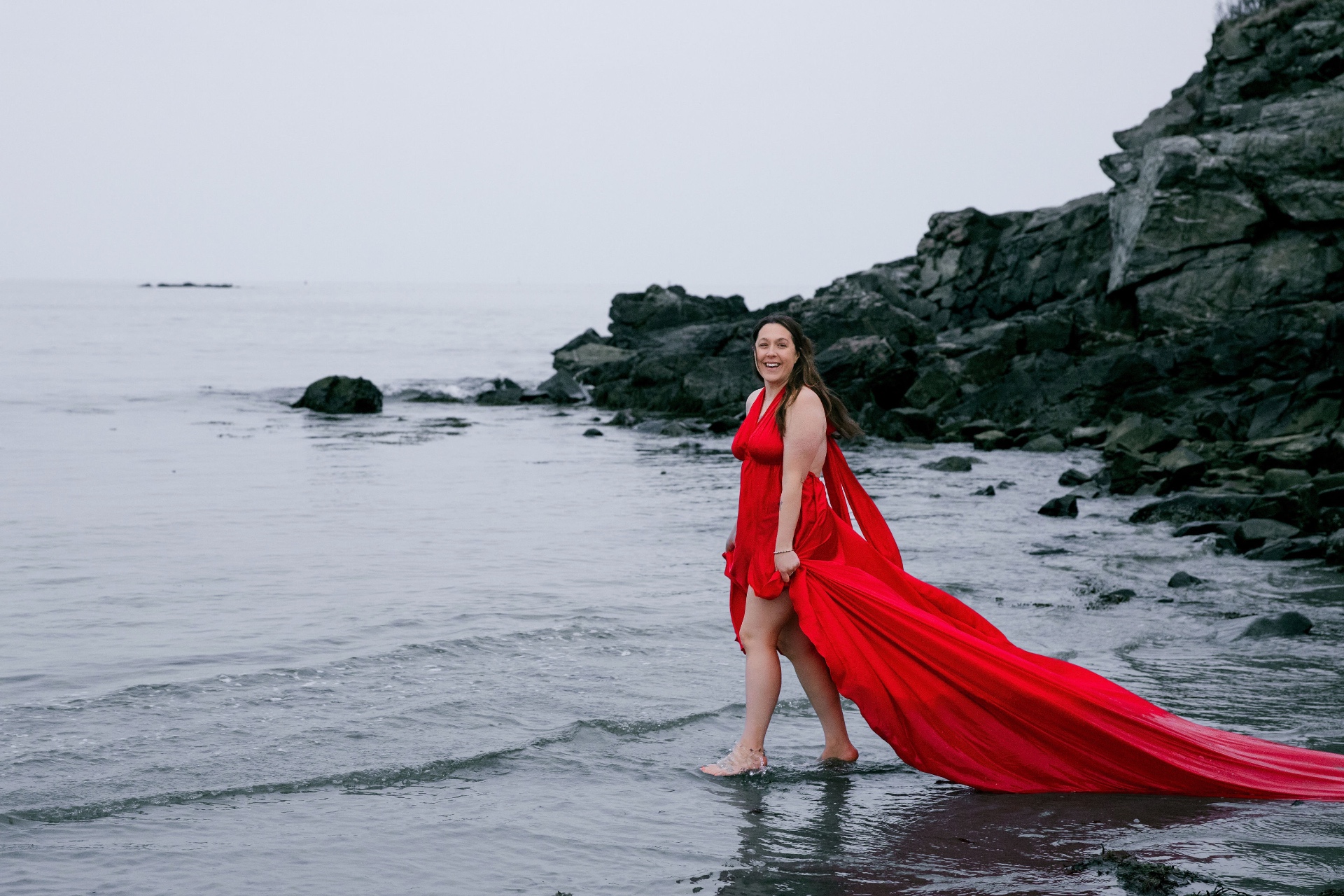 Ashleigh, founder of A.C Wade Studio, on the coast in a red dress
